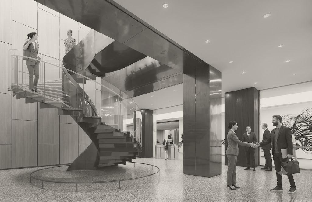 Office lobby with a dark sculptural spiral stair, timber panelling and two people greeting each other